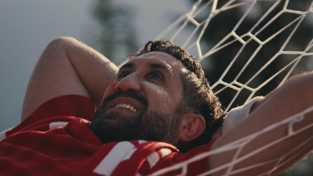 A fan relaxing in a hammock made from a World Cup goal net